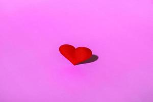 cuore rosso su uno spazio di copia sfondo rosa. concetto minimalista di san valentino foto