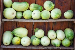 raccolto di cetrioli dall'orto della fattoria sugli scaffali di legno - cetriolo biologico fresco in vendita nel mercato foto