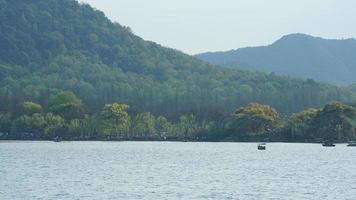 gli splendidi paesaggi lacustri nella città cinese di Hangzhou in primavera con il tranquillo lago e le fresche montagne verdi foto