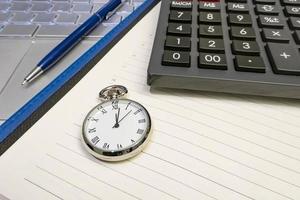 orario per affari. immagine ravvicinata di calendario, penna, orologio e calcolatrice. foto