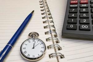 orario per affari. immagine ravvicinata di calendario, penna, orologio e calcolatrice. foto