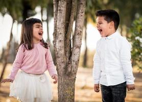 ragazza e ragazzo nel parco. faccia a faccia urlando foto