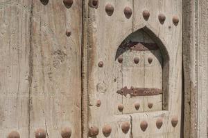 vecchia porta di legno con rivetti in metallo a bukhara, asia centrale. foto