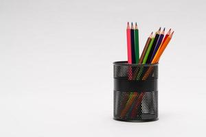 set di matite colorate in un cesto su sfondo bianco, isolato. di nuovo a scuola foto