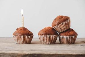 cupcakes al cioccolato con candela su tavola di legno foto