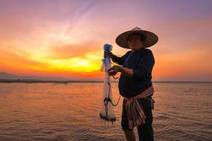 pescatore asiatico nel fiume naturale al mattino presto prima dell'alba foto