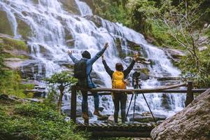 le coppie viaggiano relax per fotografare le bellissime cascate. in inverno. alla cascata mae ya chiangmai in thailandia. natura di viaggio. estate foto