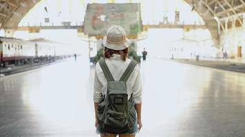 viaggiatore zaino in spalla donna asiatica viaggio a bangkok, thailandia. felice giovane femmina direzione e guardando sulla mappa della posizione alla stazione ferroviaria prima del viaggio. foto