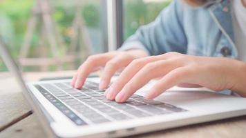 donna asiatica freelance di affari che lavora, fa progetti e invia e-mail su laptop o computer mentre è seduto sul tavolo nella caffetteria. belle donne intelligenti di stile di vita che lavorano ai concetti della caffetteria. foto