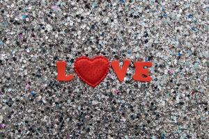 la parola amore in lettere rosse e un cuore su uno sfondo glitterato lucido per san valentino foto