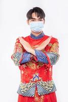 l'uomo indossa il vestito e la maschera cheongsam mostra che le persone non indossano la maschera non possono venire a fare acquisti nel capodanno cinese