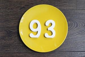 il numero novantatre su un piatto giallo. foto