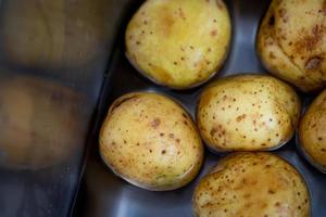 patate intere fresche e lavate. preparando la cena. foto