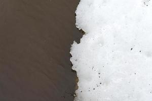 acqua marrone e neve bianca. foto