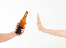 mano femminile rifiutare una bottiglia di birra isolata su bianco background.anti concetto di alcol. copia spazio foto