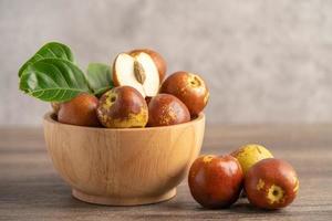 frutta di giuggiola o datteri cinesi in ciotola di legno, cibo sano. foto