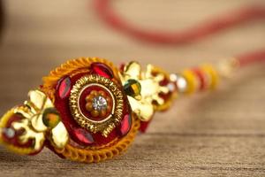 festival indiano raksha bandhan sfondo con un elegante rakhi, chicchi di riso e kumkum. un tradizionale cinturino da polso indiano che è un simbolo di amore tra fratelli e sorelle. foto