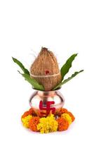 kalash di rame con cocco e foglia di mango e pooja thali con diya, kumkum e dolci con decorazione floreale su sfondo bianco. essenziale nella puja indù. foto