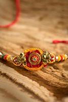 festival indiano raksha bandhan sfondo con un elegante rakhi, chicchi di riso e kumkum. un tradizionale cinturino da polso indiano che è un simbolo di amore tra fratelli e sorelle. foto