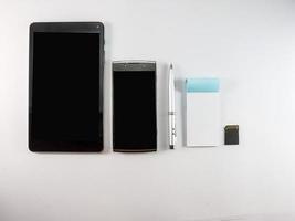 tablet pc smartphone blocco note penna e schede di memoria sfondo bianco foto