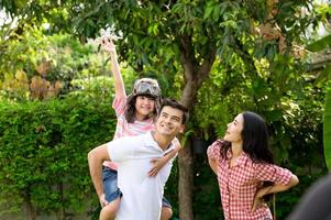 una giovane famiglia felice trascorre il tempo giocando insieme nel giardino davanti casa la vacanza. foto