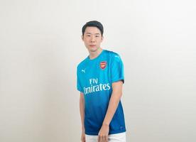 bangkok, thailandia - 27 nov 2021 - giovane uomo asiatico che indossa una camicia arsenale con sfondo bianco. foto