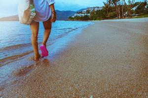 natura di viaggio donna asiatica. viaggiare rilassati. camminando sulla spiaggia. in estate foto