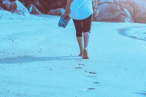 natura di viaggio donna asiatica. viaggiare rilassati. camminando sulla spiaggia. in estate foto