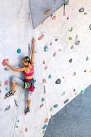 una donna sta scalando una parete da arrampicata foto