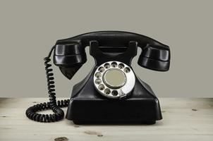 vecchio telefono vintage con disco rotante su sfondo grunge tavolo in legno foto