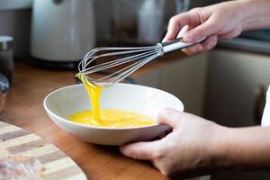 sbattere un uovo. preparazione degli ingredienti per la panatura. cucina casalinga. foto