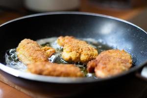 pezzi di pollo impanati fritti. preparazione di una cena tradizionale. foto