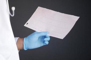 mano del medico in guanti medici che analizzano il diagramma cardio. foto