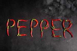 peperoncino rosso brillante su sfondo grigio cemento. cibo piccante, ingredienti foto