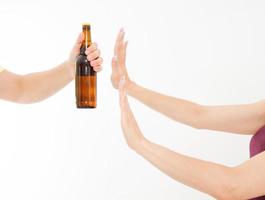 mano femminile rifiutare una bottiglia di birra isolata su bianco background.anti concetto di alcol. copia spazio foto