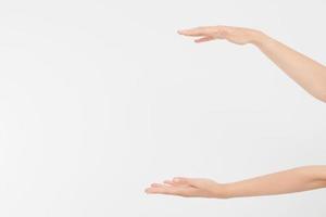 mani femminili che misurano oggetti invisibili, palmo della donna che fa gesto mentre mostra una piccola quantità di qualcosa su sfondo bianco isolato, vista laterale, primo piano, ritaglio, copia spazio foto