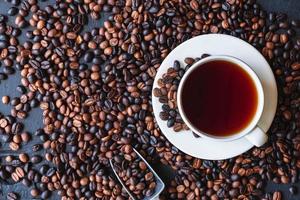 tazza di caffè e chicchi di caffè tostato foto