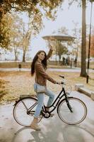 giovane donna in sella alla bicicletta il giorno d'autunno foto