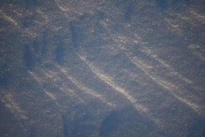 paesaggi innevati e primo piano della neve nei raggi del sole. erba e oggetti nella neve. foto