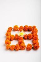 design rangoli di fiori di calendula con lampade a olio per il festival di diwali. foto