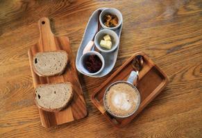 messa a fuoco selettiva sul caffè latte cremoso con pane biologico per bere e mangiare sani foto