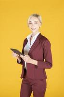 donna d'affari sta utilizzando tablet in studio sfondo giallo