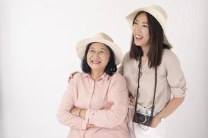 donna anziana asiatica e sua figlia su sfondo bianco, concetto di viaggio foto