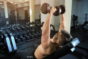 bodybuilder uomo fitness muscolare è allenamento con manubri in palestra