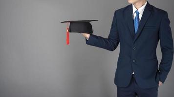 l'uomo d'affari tiene in mano il cappello di laurea, concetto di educazione aziendale foto