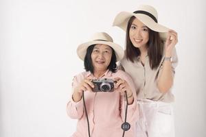 donna anziana asiatica e sua figlia su sfondo bianco, concetto di viaggio