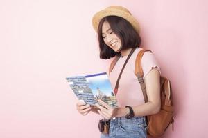 felice turista asiatico su sfondo rosa foto