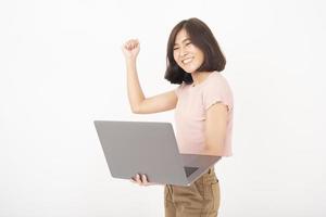 la donna teenager asiatica sveglia sta lavorando con il computer su priorità bassa bianca foto