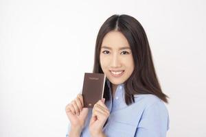 bella turista asiatica sta tenendo il passaporto su sfondo bianco foto