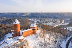 Vista panoramica aerea invernale del castello di turaida, del suo cortile ricostruito, della torre e dell'edificio di abitazione, turaida, sigulda, lettonia foto